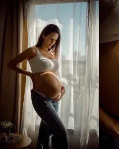 Father gently holding newborn baby on his chest, skin to skin tenderness, soft window daylight